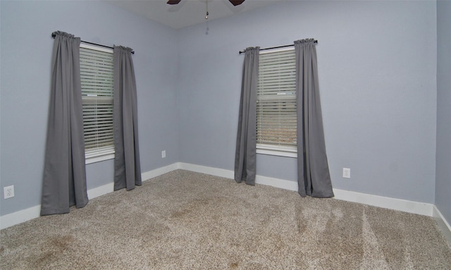 spare room with ceiling fan and carpet