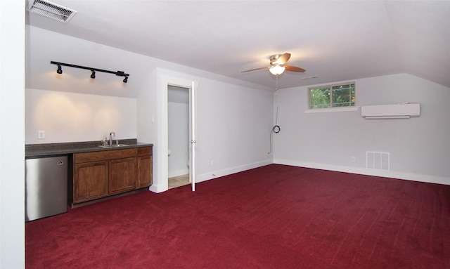 interior space with sink, a wall mounted AC, track lighting, dark carpet, and stainless steel dishwasher