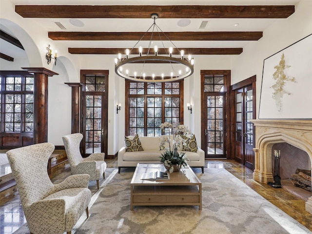 living area featuring decorative columns, a wealth of natural light, an inviting chandelier, and beam ceiling