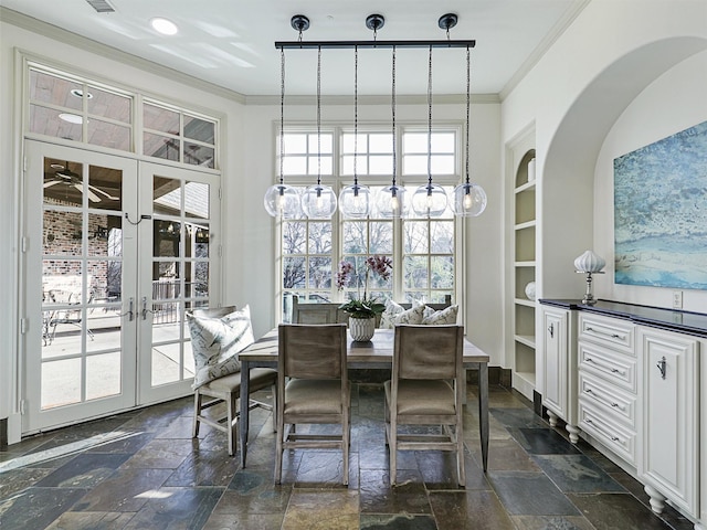 dining room with crown molding, built in features, and french doors