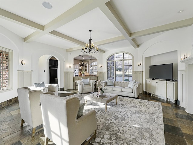 living room with beamed ceiling, coffered ceiling, and a chandelier