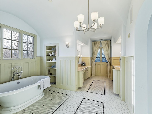 bathroom with lofted ceiling, a bathtub, and an inviting chandelier