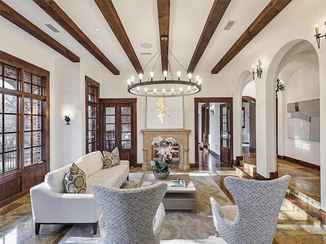 living room with a high end fireplace and beamed ceiling