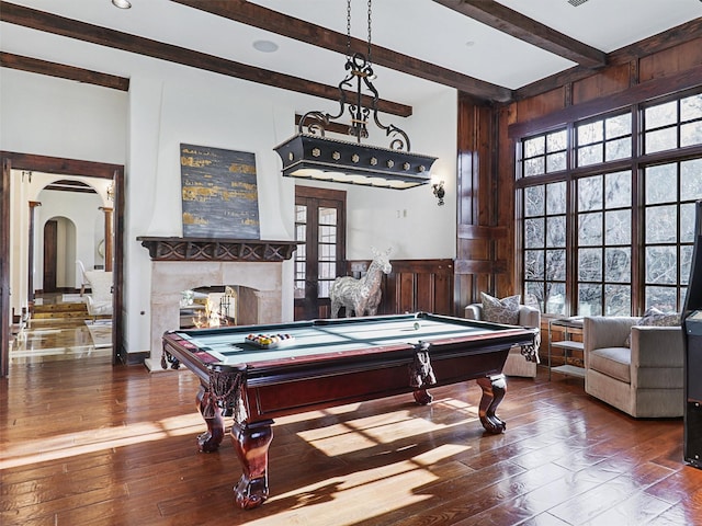 game room featuring hardwood / wood-style floors, a fireplace, billiards, beamed ceiling, and french doors