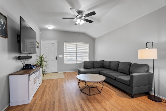 living room featuring lofted ceiling, light hardwood / wood-style flooring, and ceiling fan