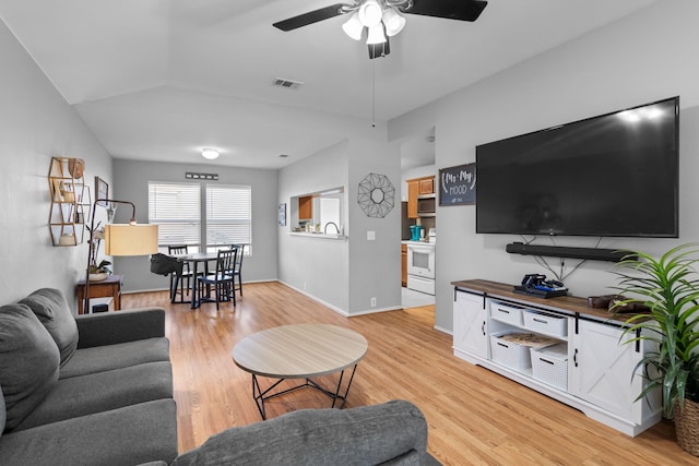 living room with lofted ceiling, light hardwood / wood-style floors, and ceiling fan