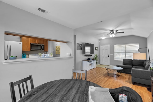 dining area with vaulted ceiling, light hardwood / wood-style floors, and ceiling fan