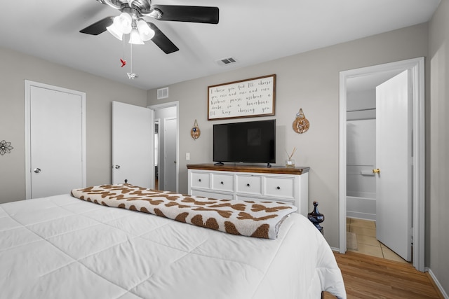 bedroom with ceiling fan, light hardwood / wood-style floors, and ensuite bath