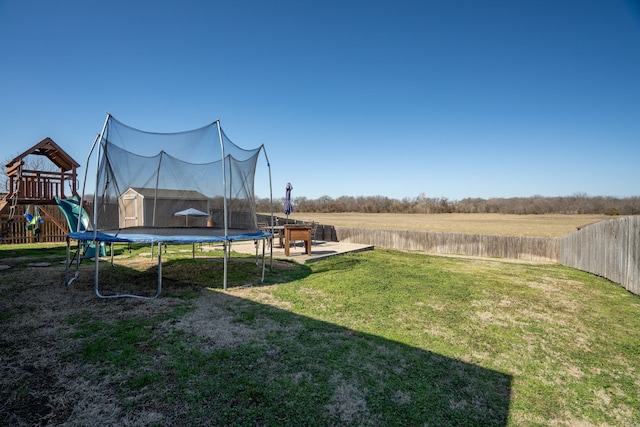 view of yard with a playground, a trampoline, and a rural view