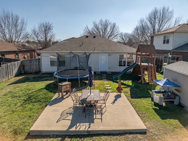 back of property with a patio, a playground, a trampoline, and a lawn