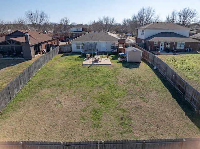 view of yard featuring a trampoline, a playground, and a shed