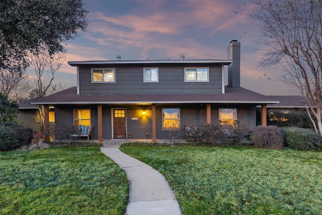 view of front of home with covered porch and a lawn