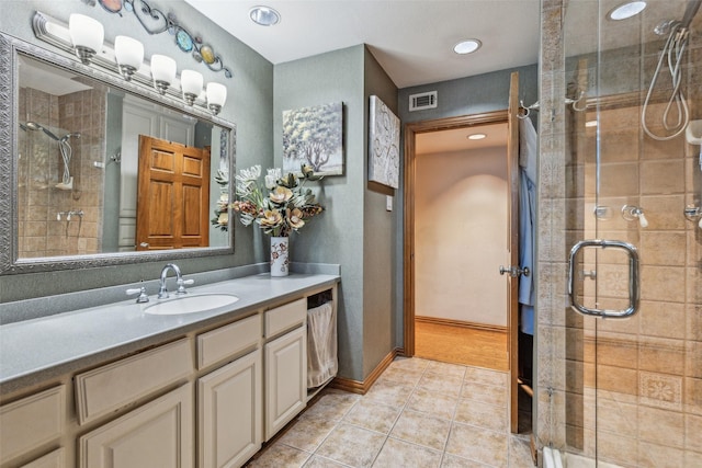 bathroom with tile patterned floors, a shower with shower door, and vanity