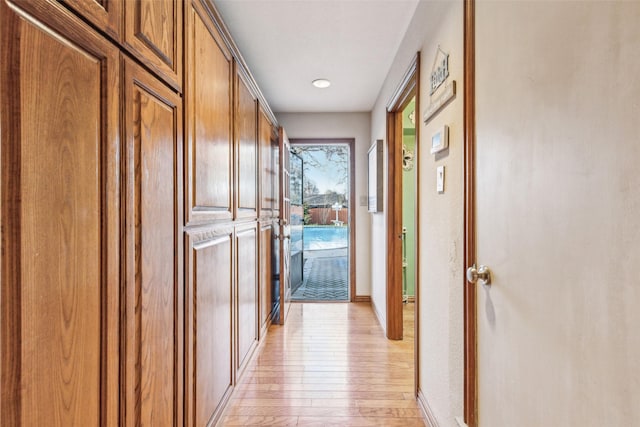 corridor with light hardwood / wood-style floors