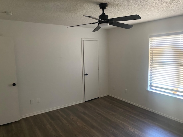 spare room with ceiling fan, dark hardwood / wood-style floors, and a textured ceiling