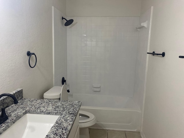 full bathroom with tile patterned flooring, vanity, tiled shower / bath, and toilet