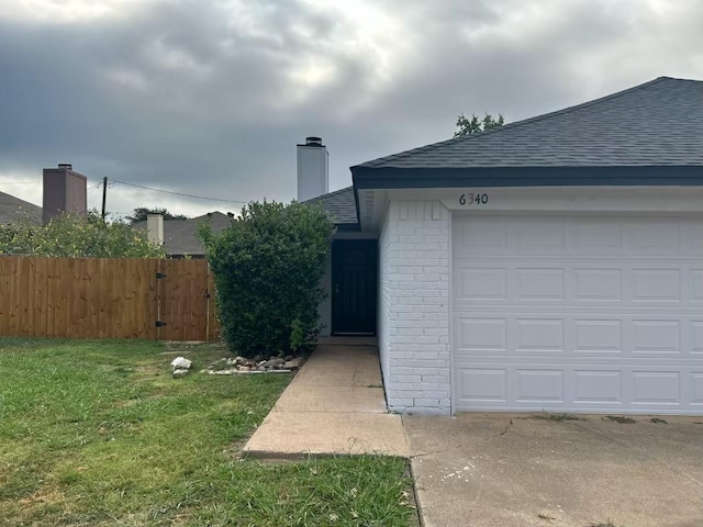 exterior space featuring a garage and a front lawn