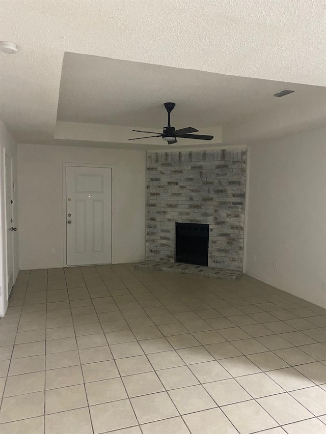 unfurnished living room featuring light tile patterned floors, a textured ceiling, and ceiling fan