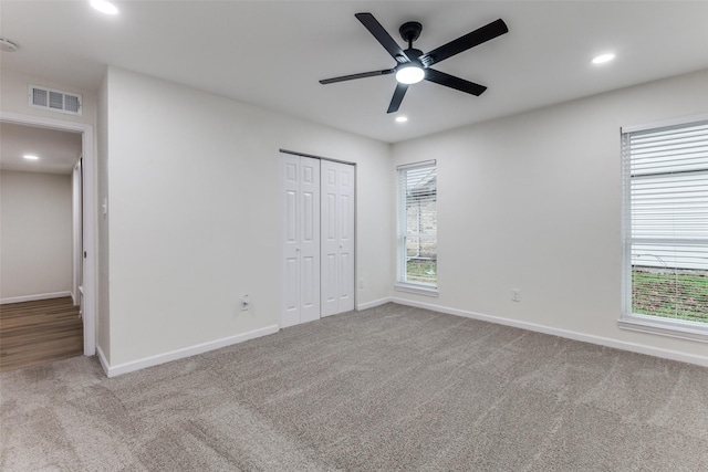 unfurnished bedroom featuring light carpet, a closet, and ceiling fan