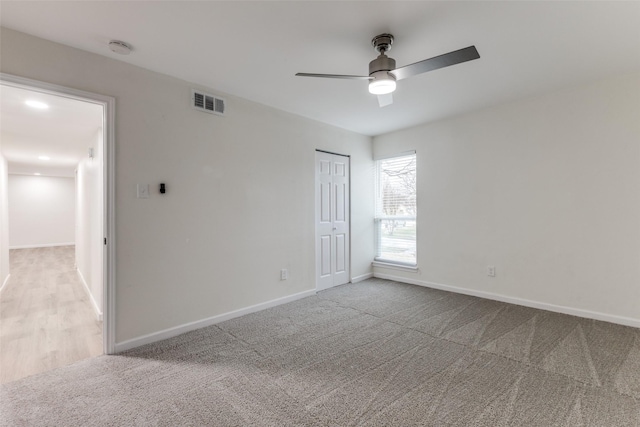 spare room featuring ceiling fan and light colored carpet