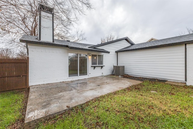 rear view of property featuring a patio, a yard, and central AC unit