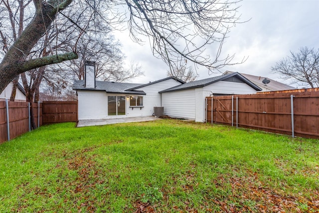 rear view of property featuring cooling unit, a yard, and a patio