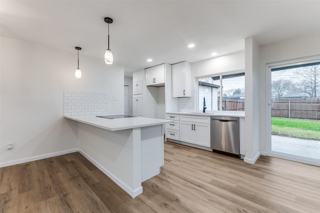 kitchen featuring light hardwood / wood-style flooring, dishwasher, white cabinetry, hanging light fixtures, and kitchen peninsula