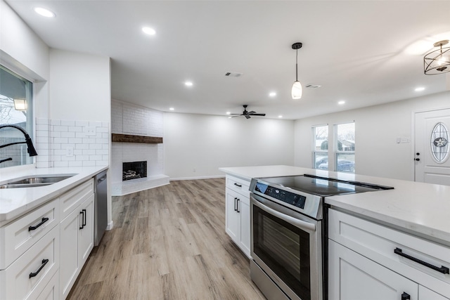 kitchen with stainless steel appliances, hanging light fixtures, sink, and white cabinets