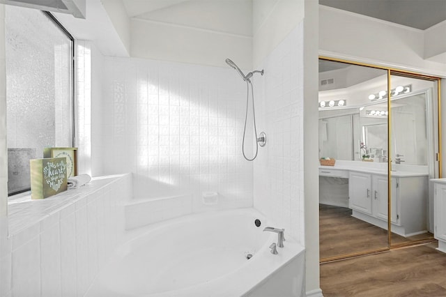 bathroom featuring tiled shower / bath combo, vanity, and hardwood / wood-style floors