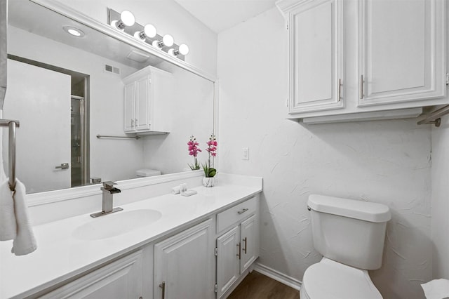 bathroom featuring vanity, hardwood / wood-style floors, and toilet