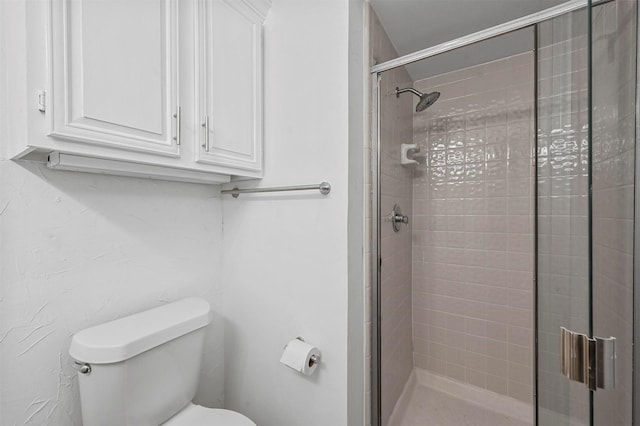 bathroom featuring walk in shower and toilet