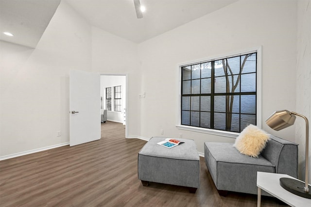 sitting room with dark hardwood / wood-style flooring, high vaulted ceiling, and ceiling fan