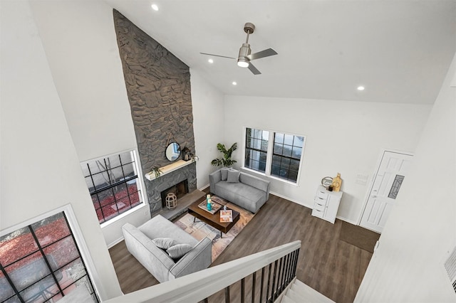 living room featuring vaulted ceiling, ceiling fan, a fireplace, and hardwood / wood-style floors