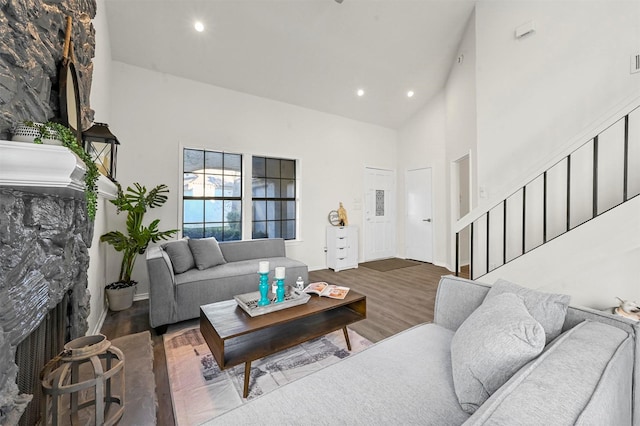 living room featuring hardwood / wood-style flooring, high vaulted ceiling, and a fireplace