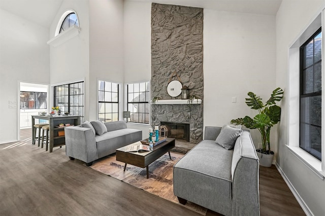 living room with a fireplace, dark hardwood / wood-style floors, and a high ceiling