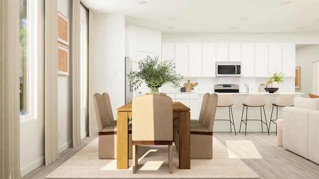 dining space with sink and light wood-type flooring