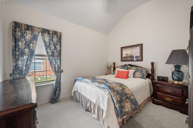 bedroom with vaulted ceiling and light colored carpet