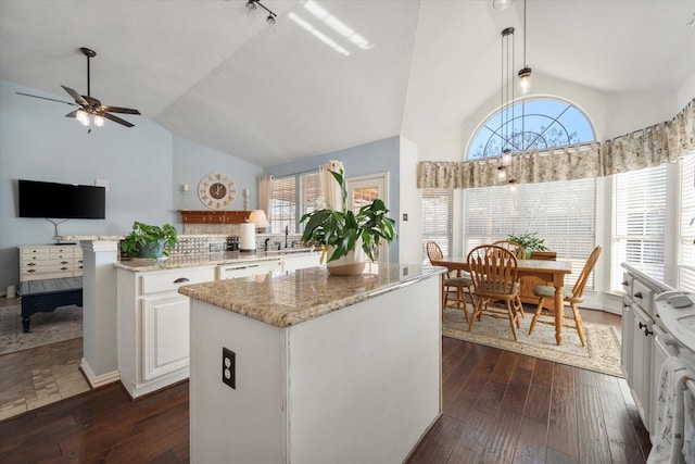 kitchen with a kitchen island, decorative light fixtures, white cabinetry, dishwasher, and dark hardwood / wood-style flooring