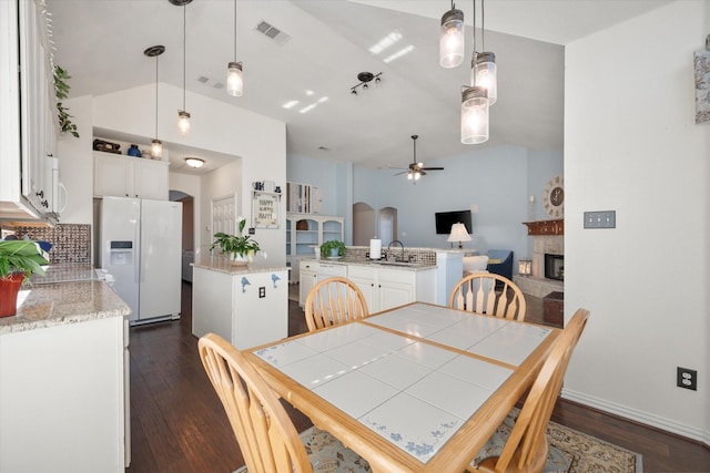 dining area with sink, vaulted ceiling, dark hardwood / wood-style floors, and ceiling fan