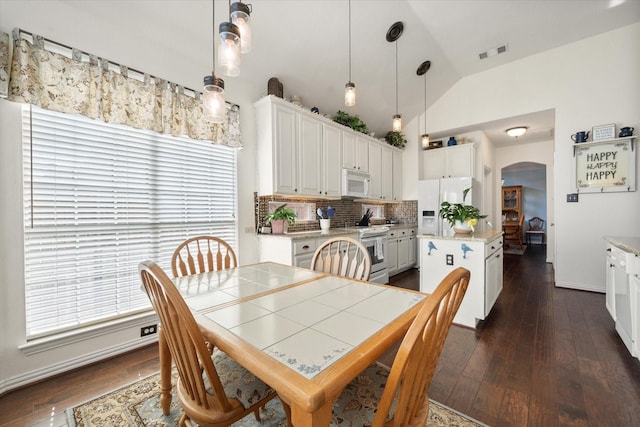 dining area with lofted ceiling and dark hardwood / wood-style floors