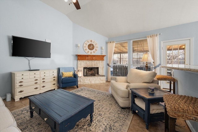 living room with lofted ceiling, a stone fireplace, and ceiling fan