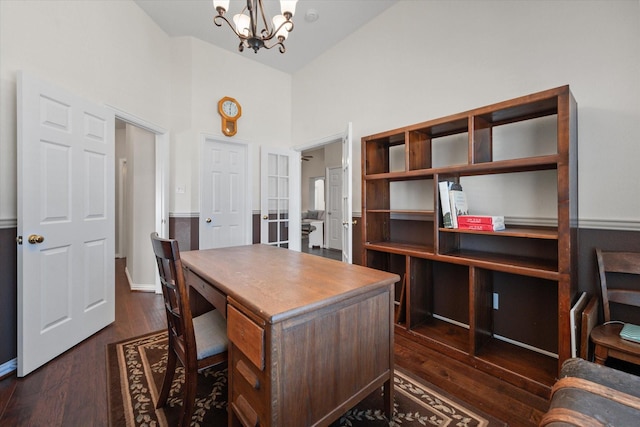 office area featuring a towering ceiling, dark hardwood / wood-style flooring, and a notable chandelier