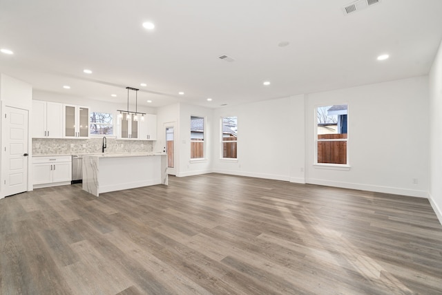 unfurnished living room with plenty of natural light, dark hardwood / wood-style floors, and sink