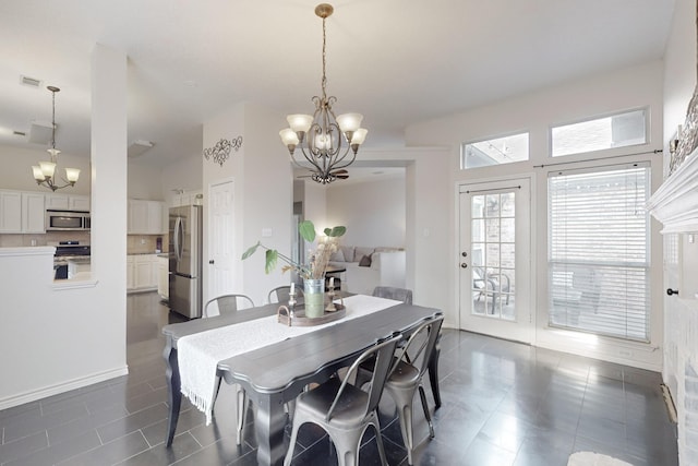 dining area featuring an inviting chandelier and dark tile patterned flooring