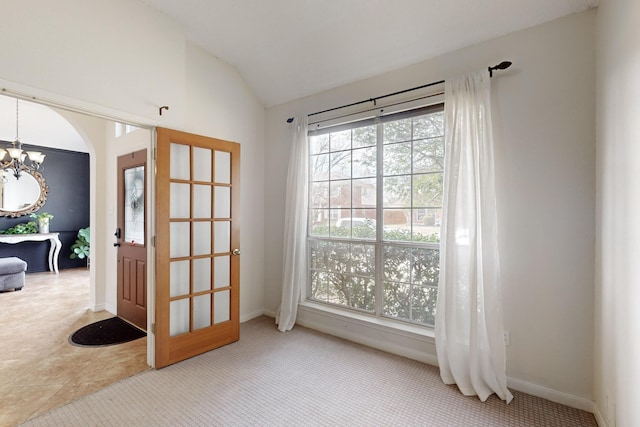 doorway to outside featuring an inviting chandelier, carpet flooring, and vaulted ceiling