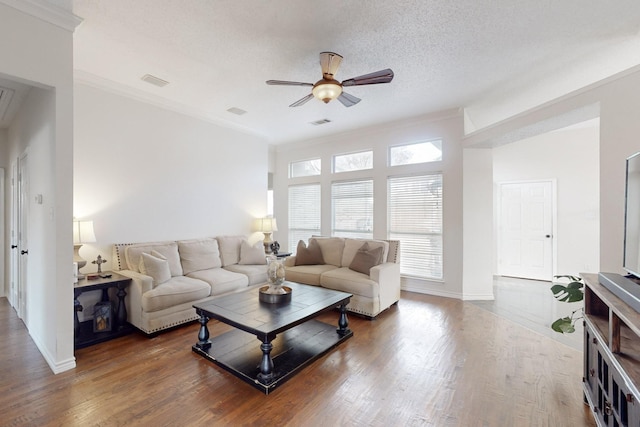 living room featuring crown molding, ceiling fan, dark hardwood / wood-style floors, and a textured ceiling