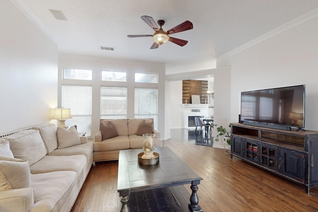 living room featuring ceiling fan, ornamental molding, and dark hardwood / wood-style floors