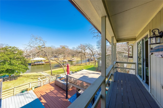 wooden terrace featuring a yard and a water view