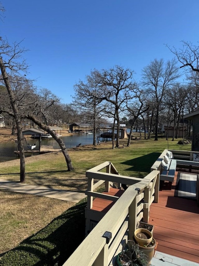 wooden deck featuring a water view and a yard