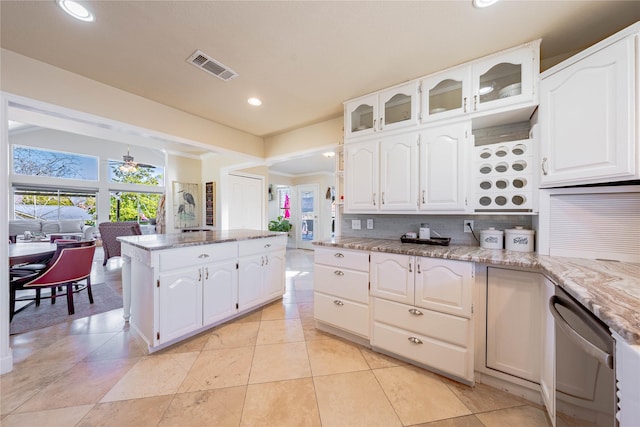 kitchen featuring dishwasher, light stone counters, tasteful backsplash, and white cabinets